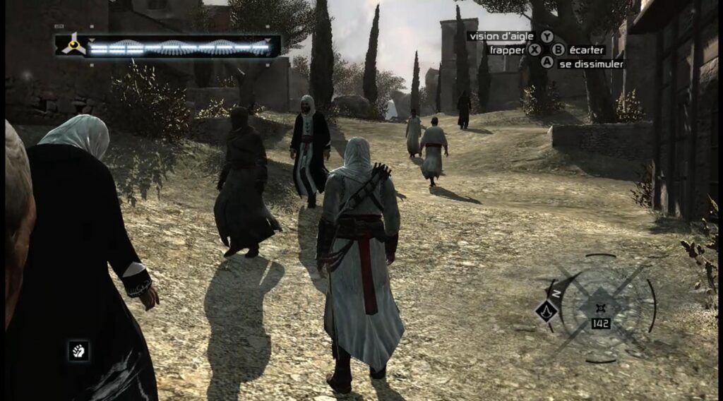 Third-person gameplay from the original Assassin's Creed showing Altaïr in white robes walking through a crowded, dusty village path.