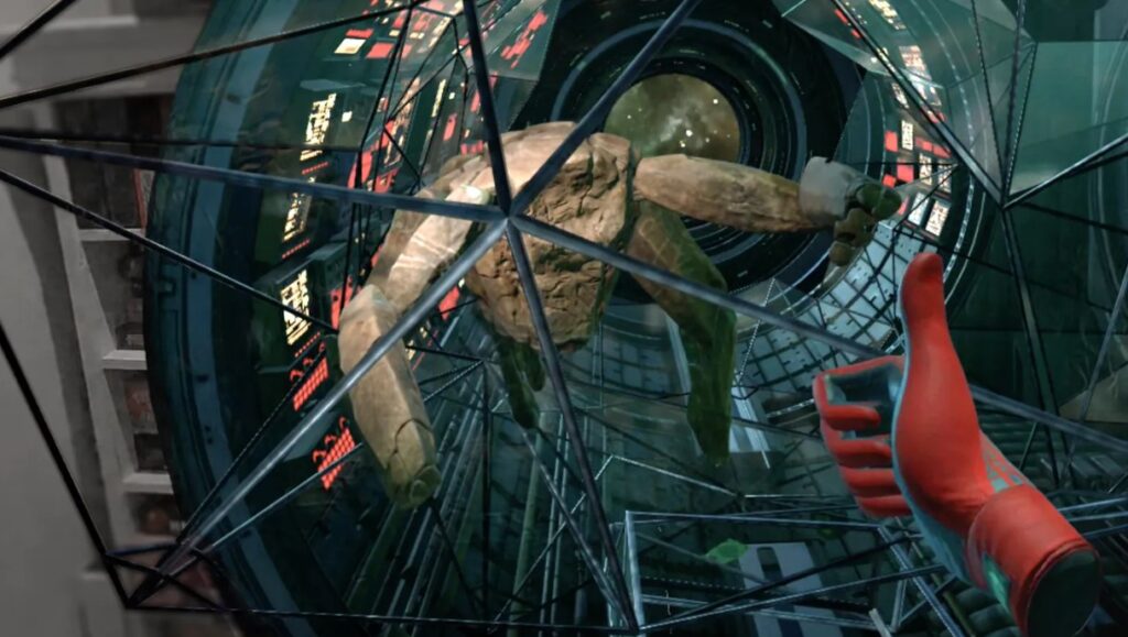 A first-person view of a hand in a red and blue space suit giving a thumbs-up to a five-legged, rock-like alien behind a geometric glass barrier.